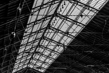 Old roof frame in interior,  architectural detail, monochrome. Interior image of a roof from inside a train station.