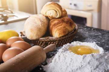 Raw dough for bread with ingredients on black background