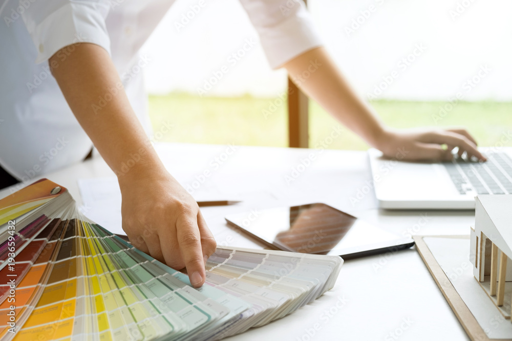 Poster interior design or graphic designer working on project of architecture drawing with work tools and color swatches, colour chart in digital tablet at workplace