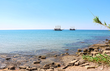 two ancient ships on a sunny cloudless day at the seashore view from the shore