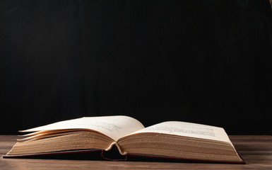 unfolded book on a black background