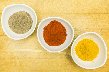 Board with colorful spices in bowls. View from above.