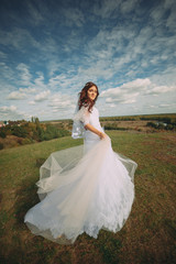 Fototapeta na wymiar the bride is spinning in the field. flying dress