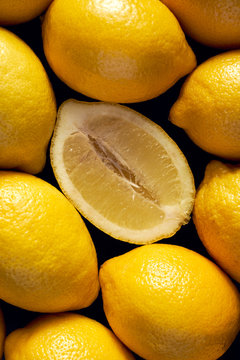 Fresh lemons on a black background, top view, close-up