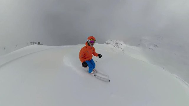 4K super wide angle one male skier skiing on ski slope on cloudy winter day
