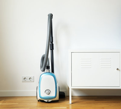 Blue Vacuum Cleaner.Room cleaning.Vacuum cleaner in an empty room.Blue Vacuum Cleaner