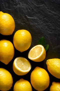 Fresh lemons on a black background, top view, close-up