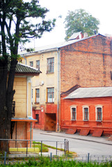 Old yellow and red houses, yard with tree