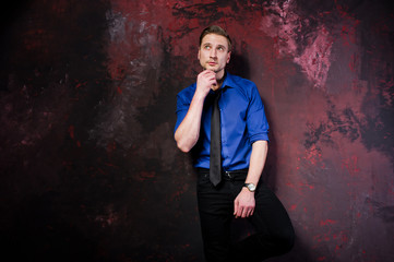 Studio portrait of stylish man, wear on blue shirt and necktie.