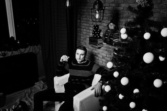 Studio portrait of man against christmass tree with decorations.