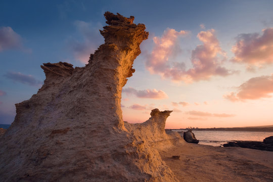 Sandrock figure in the light of sunrise on a rocky beach Northern Cyprus