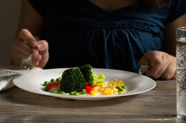 Broccoli with vegetables on a white plate. Vegetarianism. Healthy food.