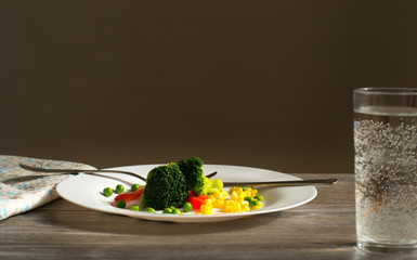 Broccoli with vegetables on a white plate. Vegetarianism. Healthy food.