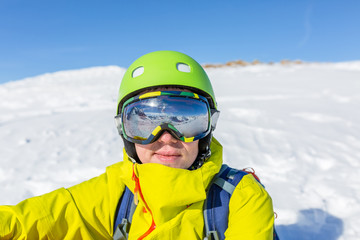 Fototapeta na wymiar Photo of sporty man wearing mask and helmet against background of snowy mountain landscape