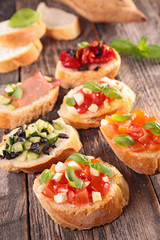 assorted bruschettas on wood background