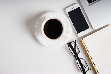 Notepad, laptop and coffee cup on wood table