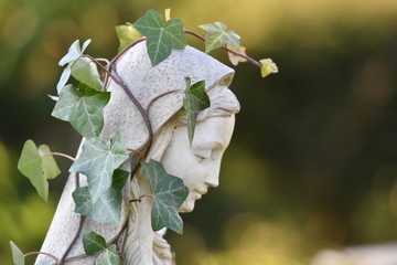 Sculpture of an angel which is covered with ivy