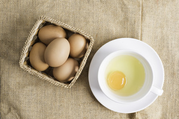 Fresh egg in white cup on cloth background.