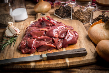 Raw chicken liver on cutting board.