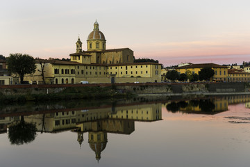 Florence, Tuscany / Italy Dawn on the Arno river embankment in the historical center, View of the church and yellow houses, reflection of the city Florence in the water