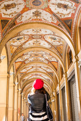 portico in Bologna, the girl in the red beret stands back © KEA
