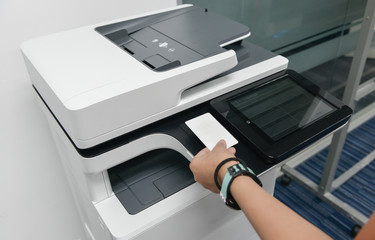 Business woman hand is using smart card with printer to printing document