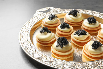 Delicious canapes with black caviar on  metal tray