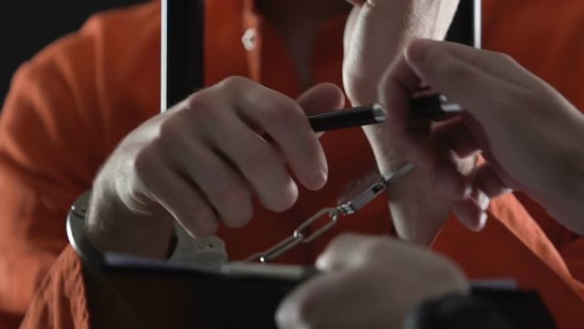 Handcuffed killer signing police cooperation document and getting out of prison