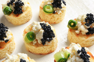 Tasty black caviar appetizer on white background
