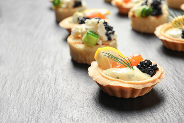 Tasty black caviar appetizers on slate plate