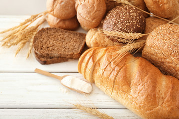 Freshly baked bread, flour and spikes on table