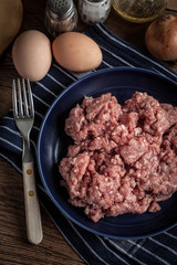 Minced meat on wooden background.