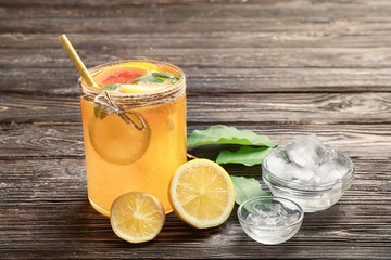 Tasty lemonade with citrus fruits in glass on table