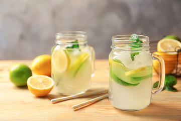 Tasty lemonade with mint in mason jars on table