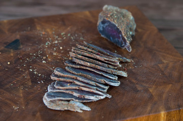 Portion of Beef Jerky cutting into slice on a cutting table with a kitchen knife on vintage wooden...