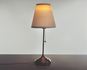 Stylish lamp on table against light background