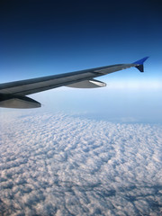 Flugzeugflügel über blauem Himmel mit Wolkenansicht