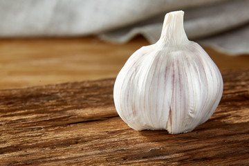 Garlic close up on wooden plate on rustic background, shallow depth of field, selective focus, macro