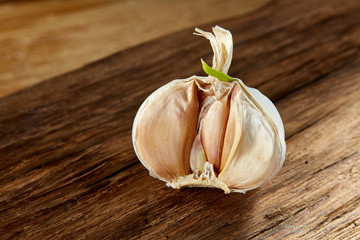 Garlic close up on wooden plate on rustic background, shallow depth of field, selective focus, macro