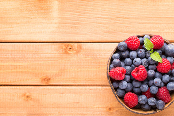 Juicy and fresh blueberries with green mint on rustic blue table.