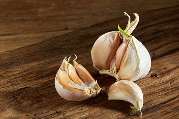 Garlic close up on wooden plate on rustic background, shallow depth of field, selective focus, macro
