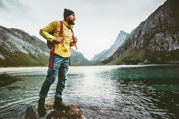 Man backpacker walking on Horseid beach in Norway Travel lifestyle wanderlust concept adventure...