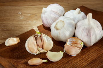 Garlic close up on wooden plate on rustic background, shallow depth of field, selective focus, macro