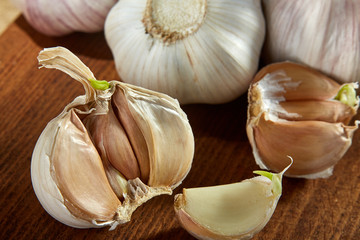Garlic close up on wooden plate on rustic background, shallow depth of field, selective focus, macro