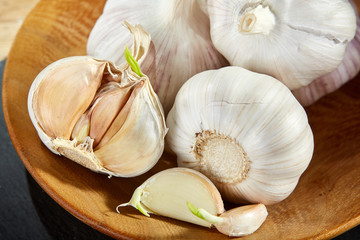 Garlic close up on wooden plate on black board,shallow depth of field, selective focus, macro
