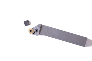 Токарный резец. Оснастка для токарного станка по металлу. Металлорежущее оборудование. Белый фон. Turning cutter. Equipment for the lathe on metal. Metal-cutting equipment. White background