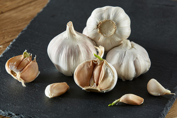 Garlic close up on wooden plate on black board,shallow depth of field, selective focus, macro