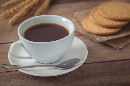 Cup of coffee and crackers on wooden table