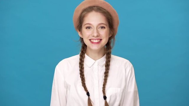 Portrait closeup of gorgeous stylish lady 20s wearing french beret expressing happiness covering mouth in excitement, isolated over blue background