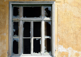 Old broken window on the yellow wall
